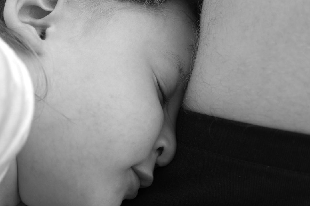 Kind kuschelt sich schlafend an